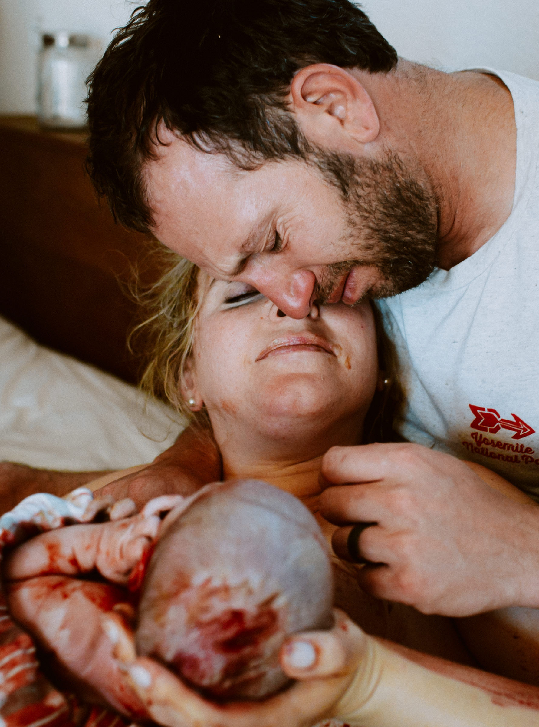 Dad kissing partner moments after birth